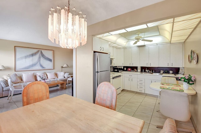 kitchen with light tile patterned floors, freestanding refrigerator, ceiling fan with notable chandelier, and white electric stove