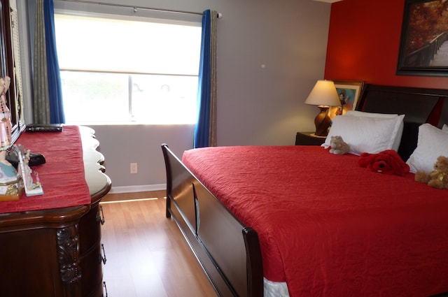bedroom with baseboards and wood finished floors