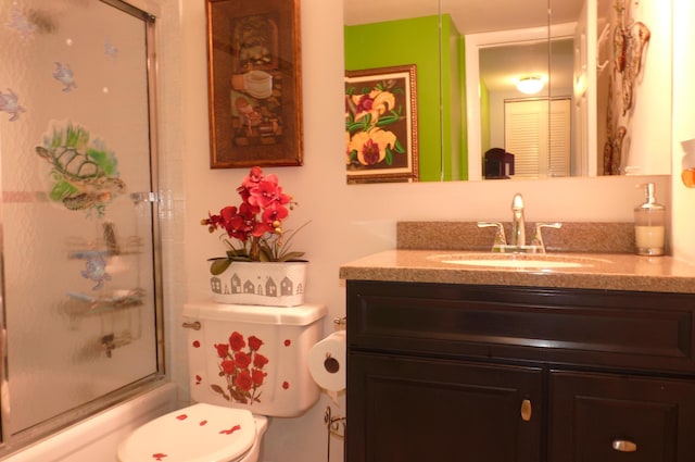 bathroom with vanity, toilet, and shower / bath combination with glass door