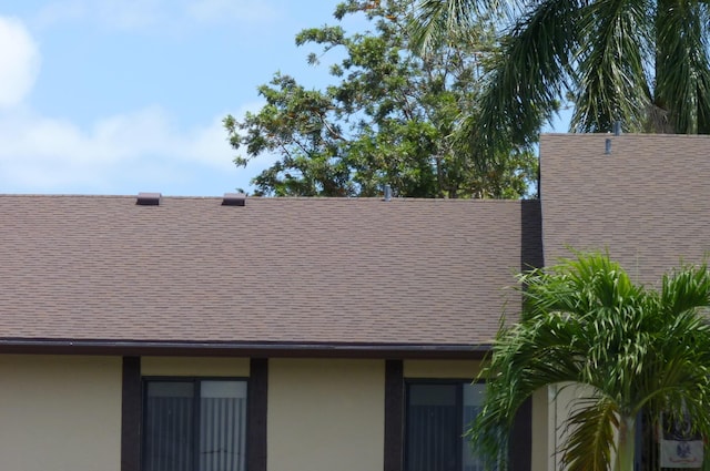 exterior details with a shingled roof and stucco siding