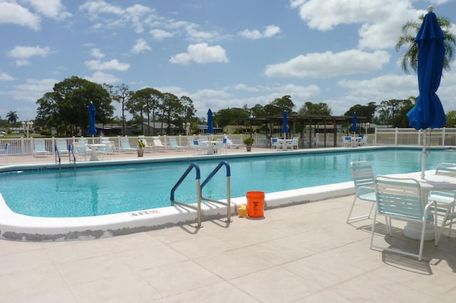 pool with fence and a patio area