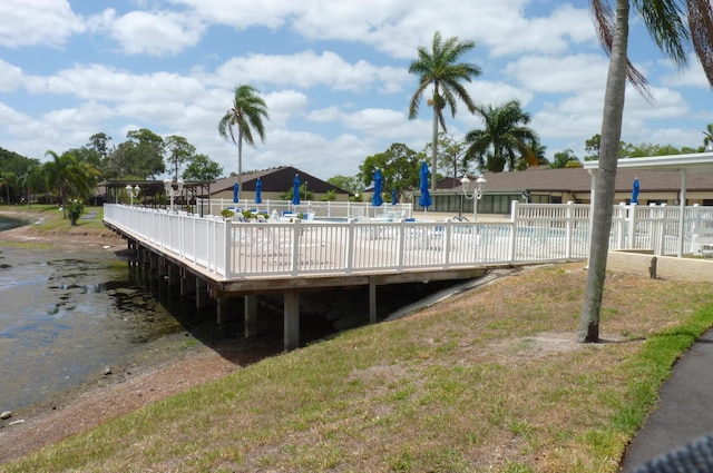 view of dock with a community pool and fence