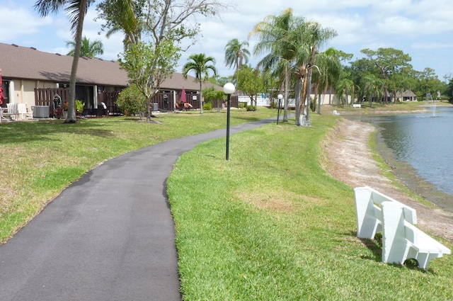 view of home's community featuring a yard, a water view, and driveway