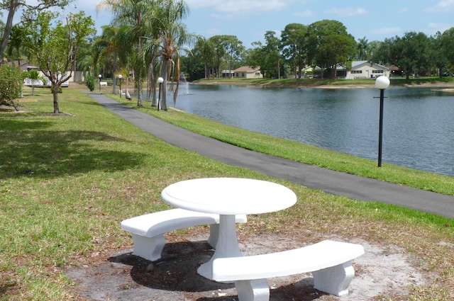 view of community featuring a lawn and a water view