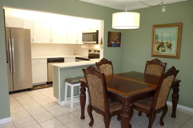 dining area with crown molding and light tile patterned floors