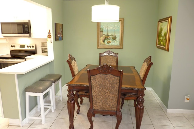 dining space with baseboards and light tile patterned floors