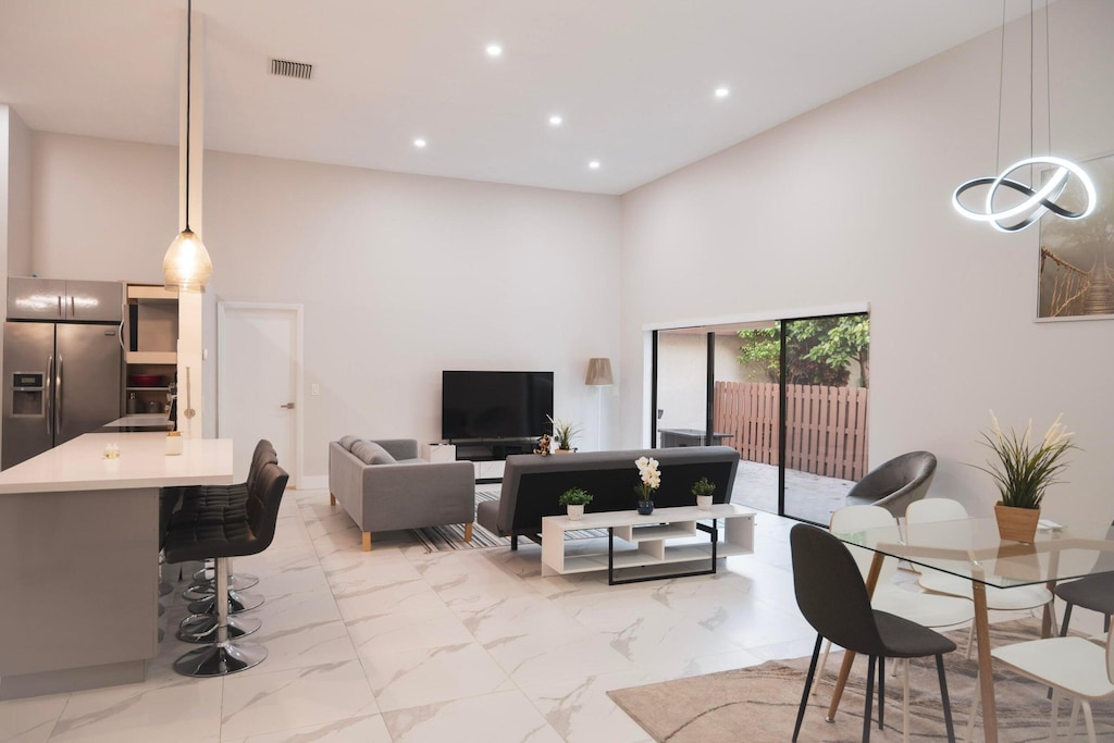 living area featuring recessed lighting, a high ceiling, visible vents, and marble finish floor
