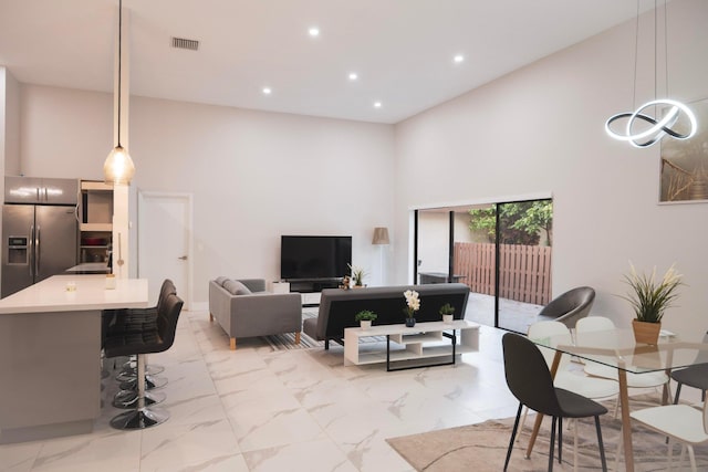 living area featuring recessed lighting, a high ceiling, visible vents, and marble finish floor