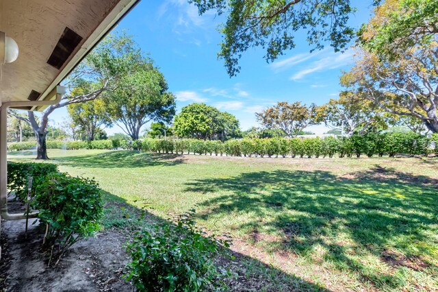 8449 Springlake Dr, Boca Raton, FL 33496 - gym featuring a textured ceiling, baseboards, and carpet