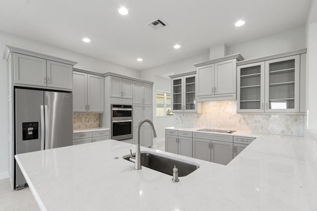 kitchen featuring visible vents, recessed lighting, gray cabinets, a sink, and appliances with stainless steel finishes