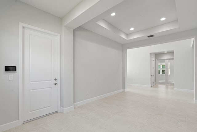 unfurnished room featuring a raised ceiling, baseboards, recessed lighting, and visible vents