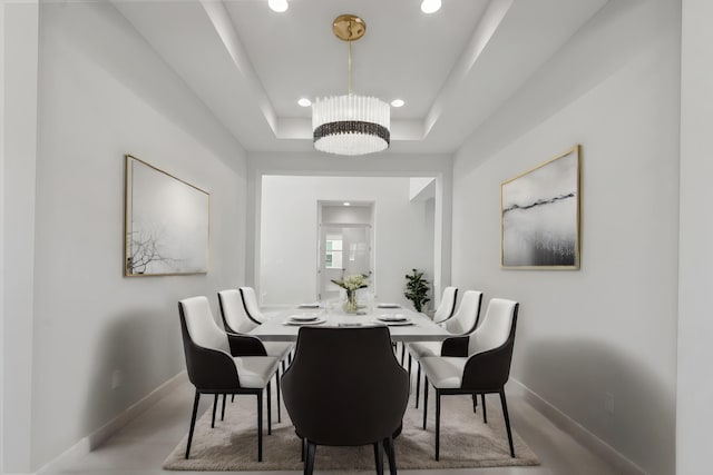 dining space with recessed lighting, baseboards, and a raised ceiling
