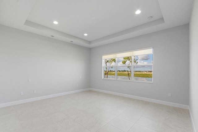 spare room featuring recessed lighting, baseboards, light tile patterned floors, and a tray ceiling