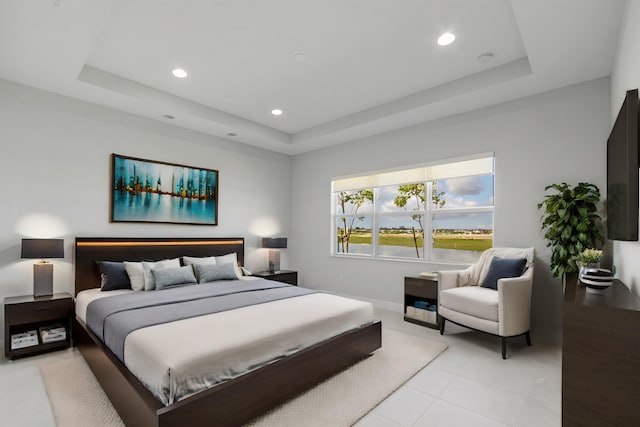 bedroom featuring recessed lighting, a tray ceiling, light tile patterned floors, and baseboards