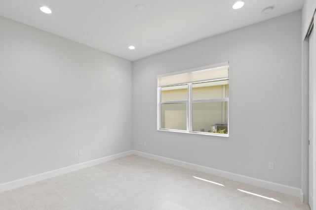 unfurnished room with baseboards and recessed lighting