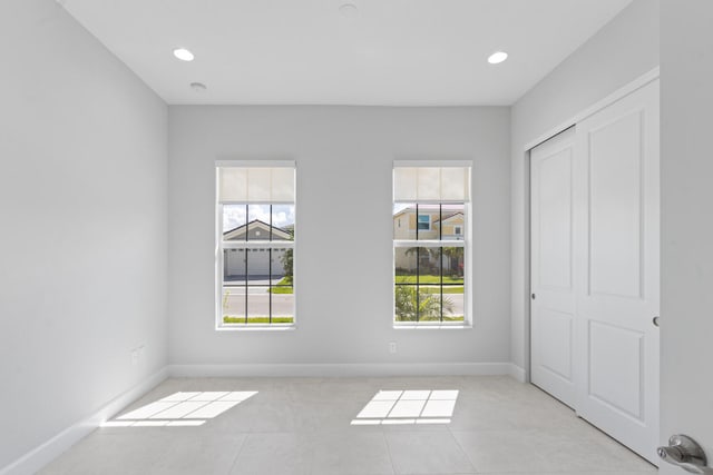 unfurnished bedroom with baseboards, tile patterned flooring, and a closet