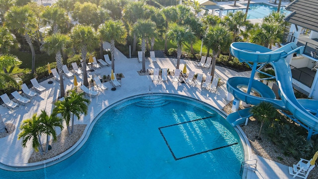 pool featuring a water slide and a patio