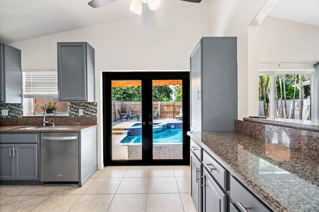 kitchen featuring a sink, gray cabinets, lofted ceiling, and dishwasher