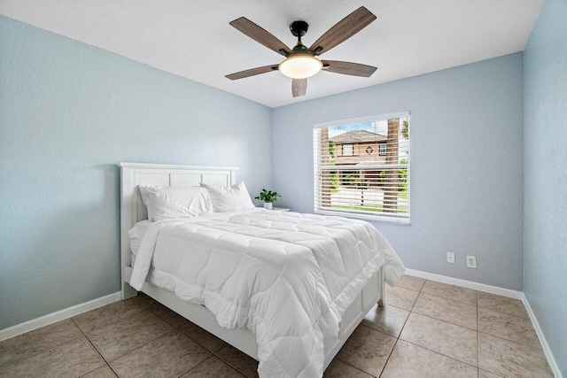bedroom featuring light tile patterned floors, baseboards, and a ceiling fan