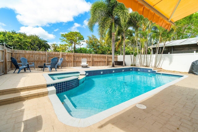view of swimming pool with a fenced backyard, a pool with connected hot tub, and a patio area
