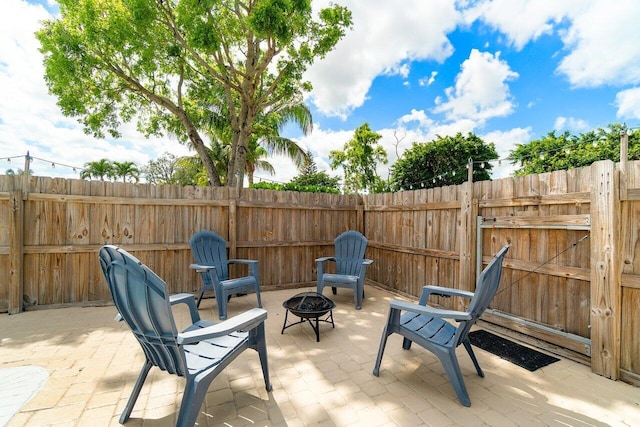 view of patio featuring fence and a fire pit