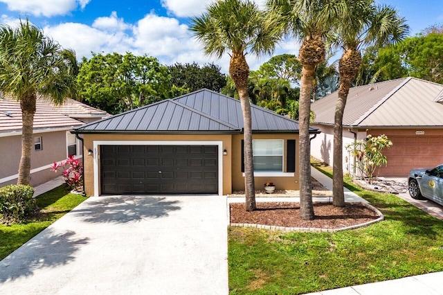 view of front of property with stucco siding, a standing seam roof, metal roof, an attached garage, and driveway