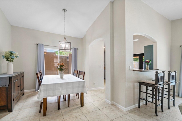dining area with arched walkways, light tile patterned floors, baseboards, lofted ceiling, and an inviting chandelier