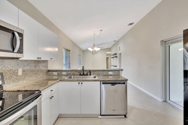 kitchen with stainless steel appliances, a chandelier, decorative backsplash, and a sink