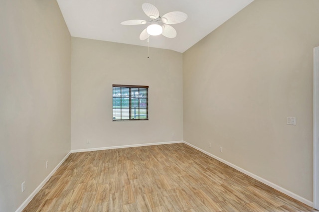 unfurnished room with light wood-style floors, baseboards, ceiling fan, and vaulted ceiling