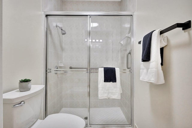full bathroom featuring a stall shower and toilet