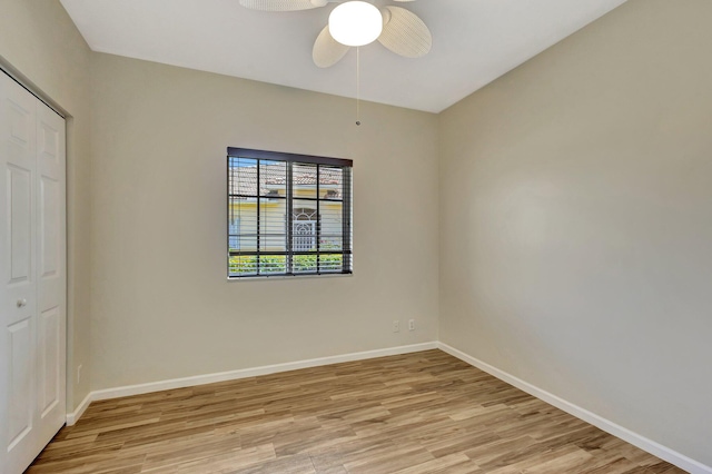unfurnished bedroom featuring light wood-style floors, baseboards, ceiling fan, and a closet