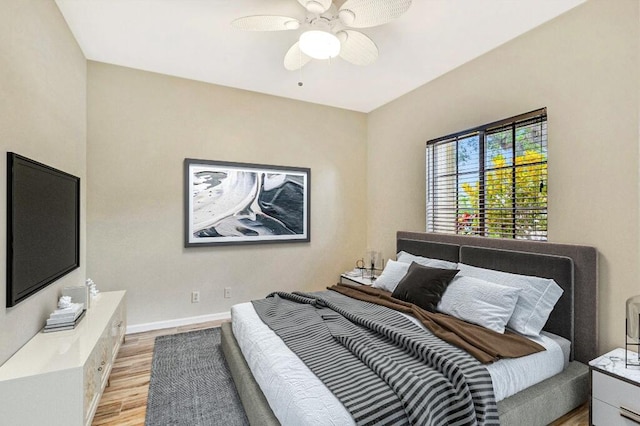 bedroom featuring light wood-style floors, baseboards, and ceiling fan