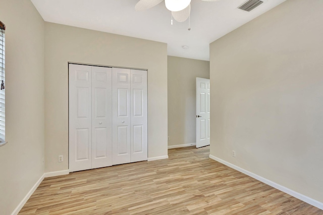 unfurnished bedroom with visible vents, a closet, baseboards, a ceiling fan, and light wood finished floors
