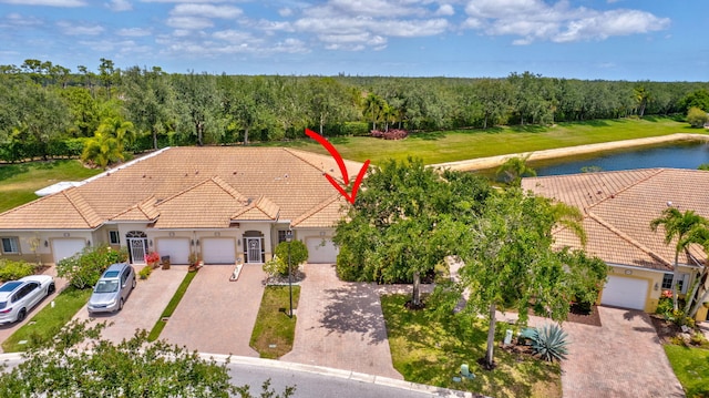 birds eye view of property featuring a water view and a forest view