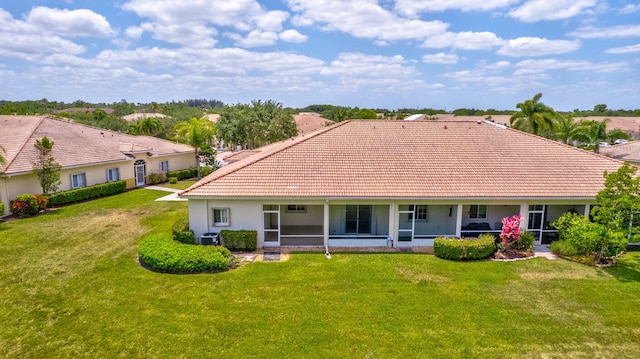 back of house featuring stucco siding, a sunroom, central AC unit, a tiled roof, and a yard