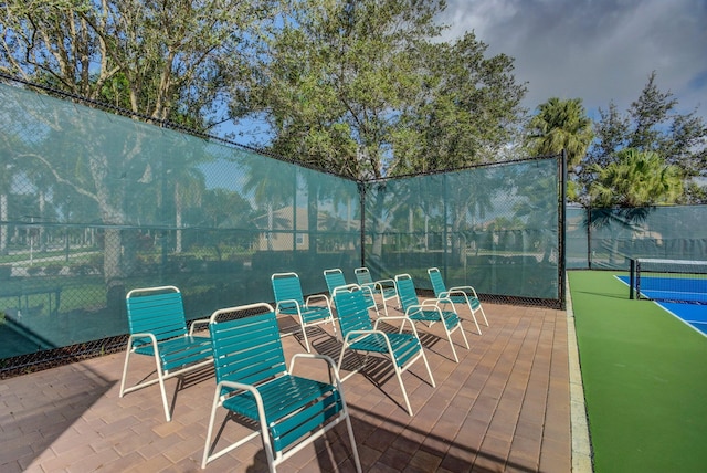 view of patio / terrace with fence and a tennis court