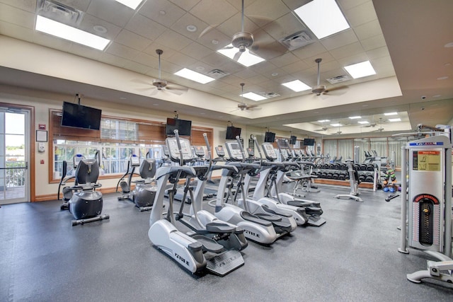 gym featuring a healthy amount of sunlight, visible vents, a ceiling fan, and a paneled ceiling