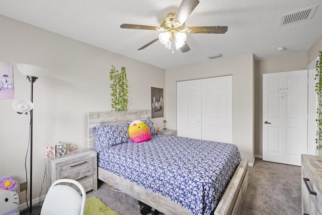 bedroom with a closet, carpet flooring, a textured ceiling, and visible vents