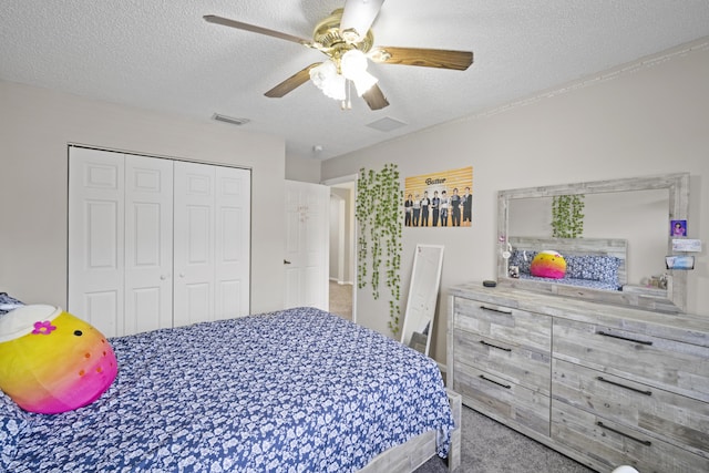 bedroom featuring visible vents, a textured ceiling, carpet floors, and a closet