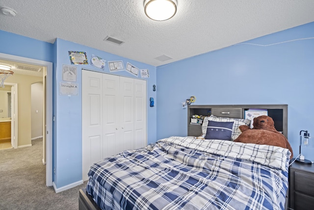 bedroom with visible vents, a textured ceiling, carpet floors, and a closet