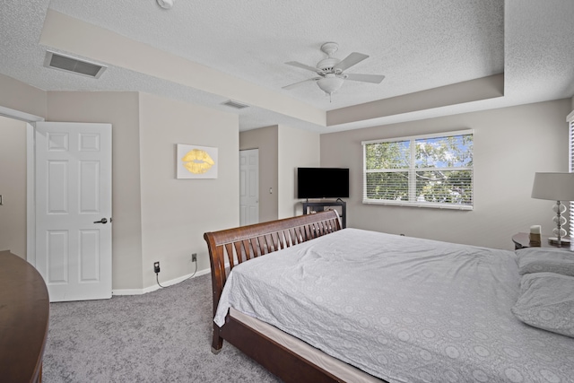 carpeted bedroom with a textured ceiling, visible vents, and baseboards