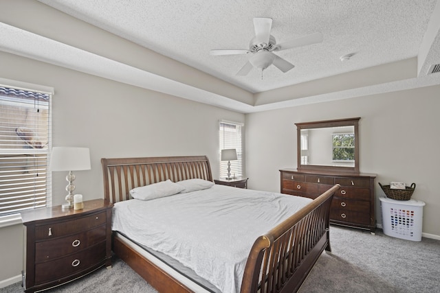 carpeted bedroom featuring visible vents, a textured ceiling, ceiling fan, and multiple windows