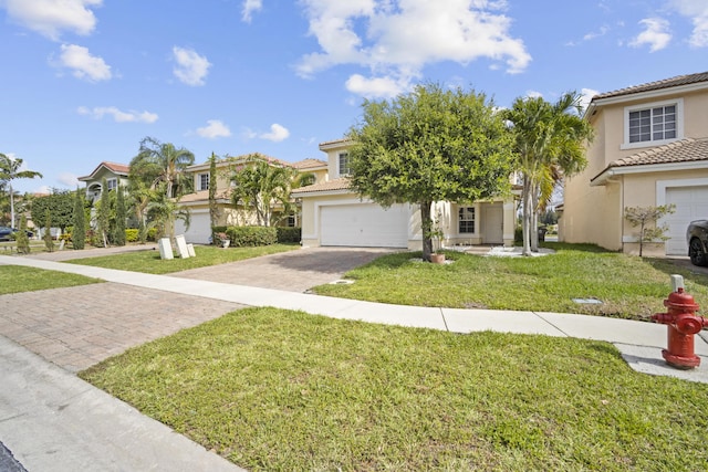 view of front of home featuring a front yard, decorative driveway, stucco siding, a tiled roof, and an attached garage
