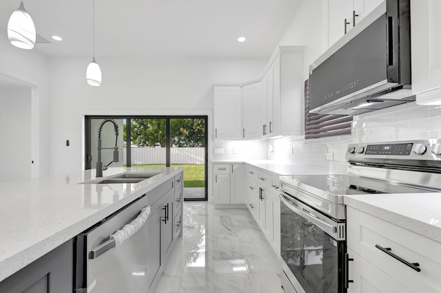 kitchen with pendant lighting, tasteful backsplash, a sink, marble finish floor, and stainless steel appliances