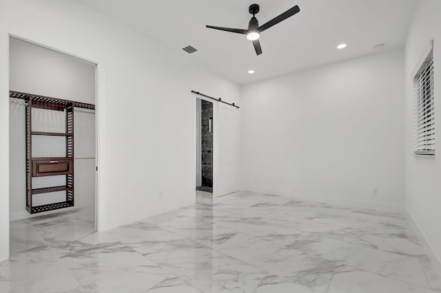 unfurnished bedroom featuring a ceiling fan, visible vents, a barn door, marble finish floor, and recessed lighting
