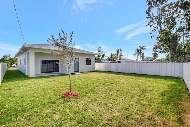 exterior space featuring a lawn, a fenced backyard, and stucco siding