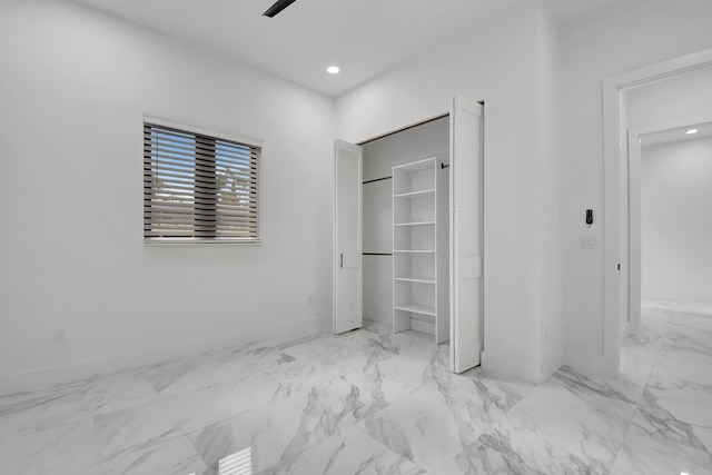unfurnished bedroom featuring baseboards, recessed lighting, and marble finish floor