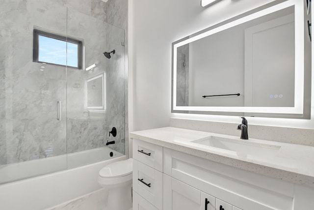 full bath featuring vanity, marble finish floor, combined bath / shower with glass door, and toilet