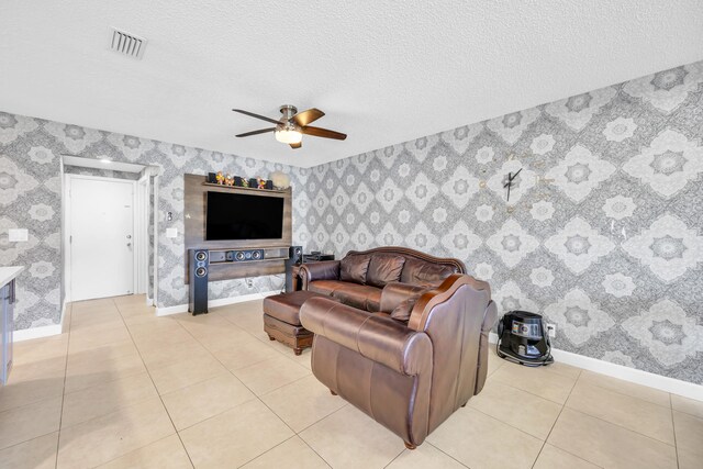 living area with baseboards, ceiling fan, wallpapered walls, and visible vents