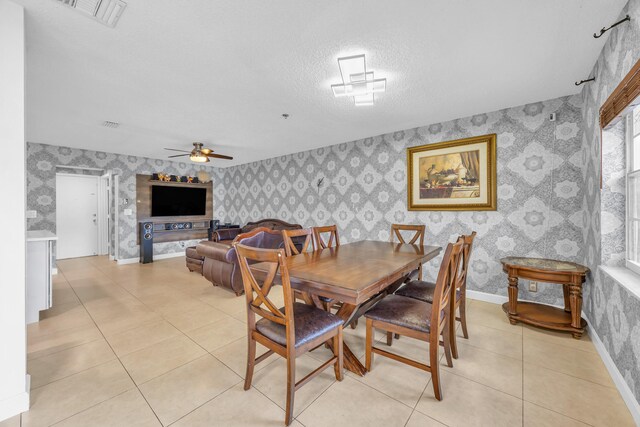 dining space featuring a ceiling fan, wallpapered walls, visible vents, and light tile patterned flooring